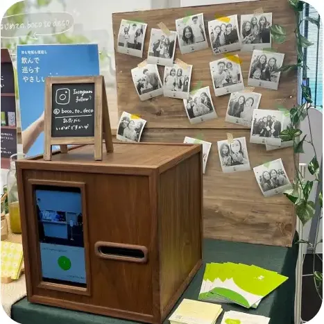 원목 영수증사진기와 나무 보드에 붙인 여러 장의 인물 영수증사진들, 안내 입간판