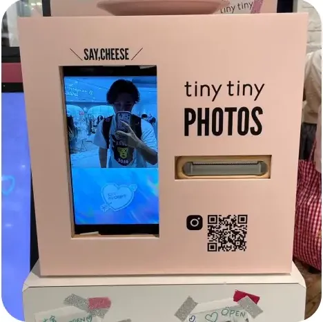 분홍색 "tiny tiny PHOTOS" 셀프 촬영 부스와 QR코드 안내